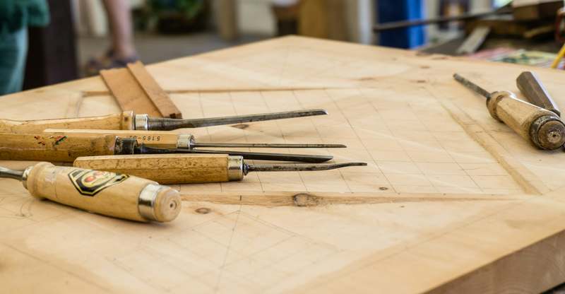 Beginner woodworking project: a simple wooden shelf being sanded by hand
