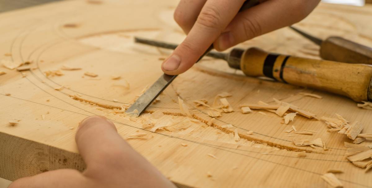 woodworking for beginners projects featuring a hand sanding a small wooden box on a workbench